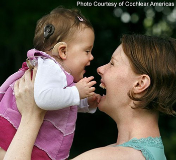 A smiling mom and baby; the baby has a cochlear implant | photo courtesy of Cochlear Americas